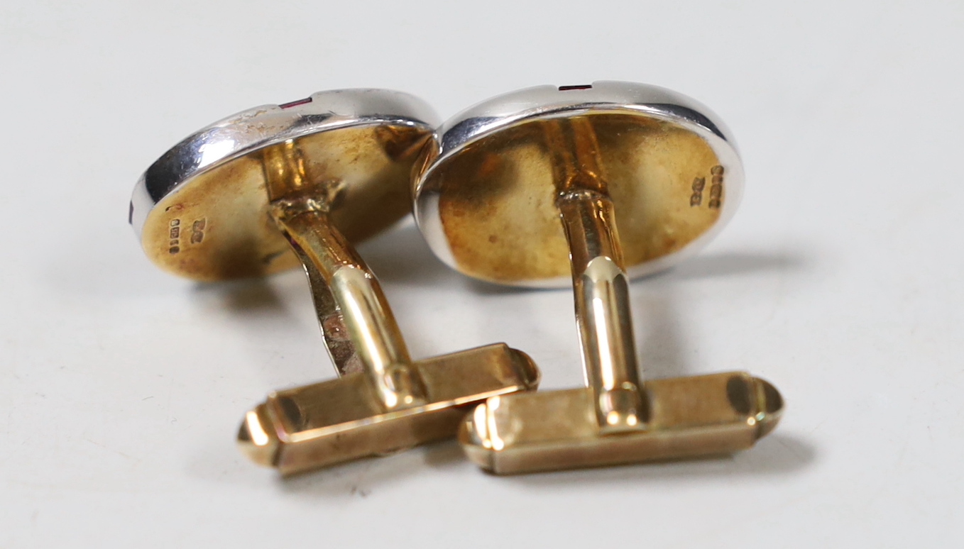 A modern pair of 9ct gold, ruby and diamond cluster set oval cufflinks, with cross motif, 21mm, gross weight 17.9 grams.